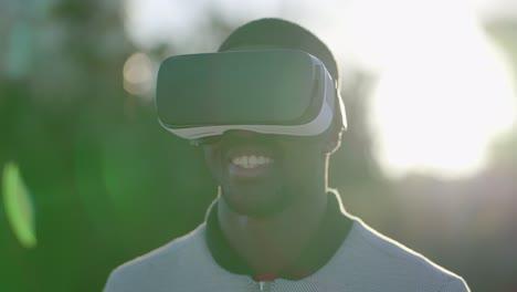 Man-putting-on-virtual-reality-glasses-in-park,-smiling